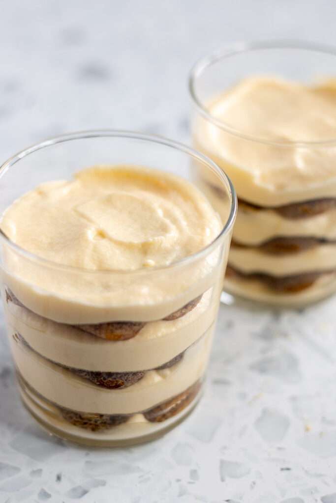 Two assembled tiramisu cups ready to chill in the refrigerator before serving.