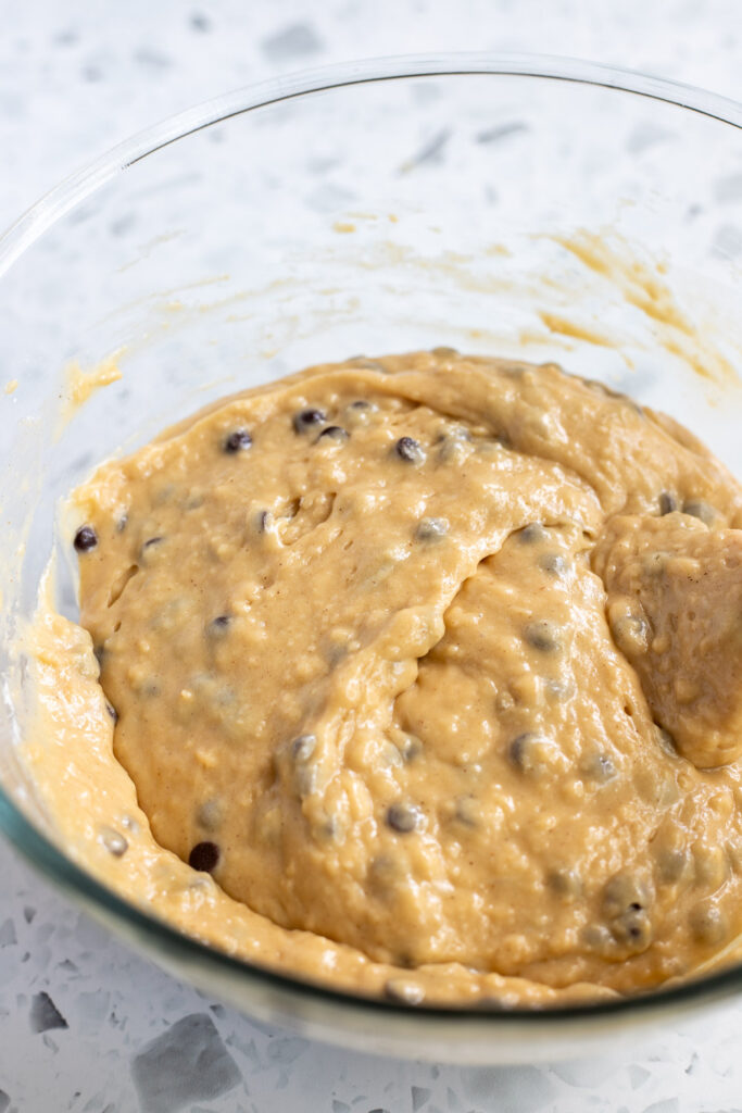 Chocolate chip muffin batter in a bowl, ready to be scooped into a muffin tin.