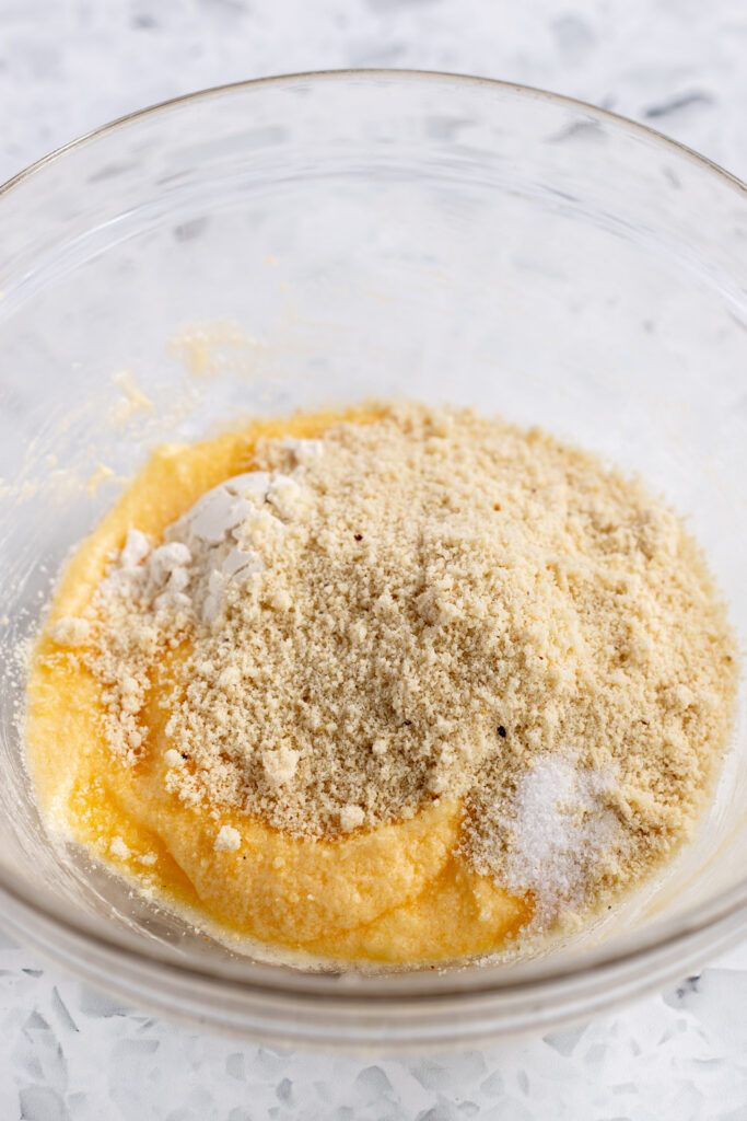 Dry ingredients being combined with butter, sugar, and eggs to prepare frangipane filling.