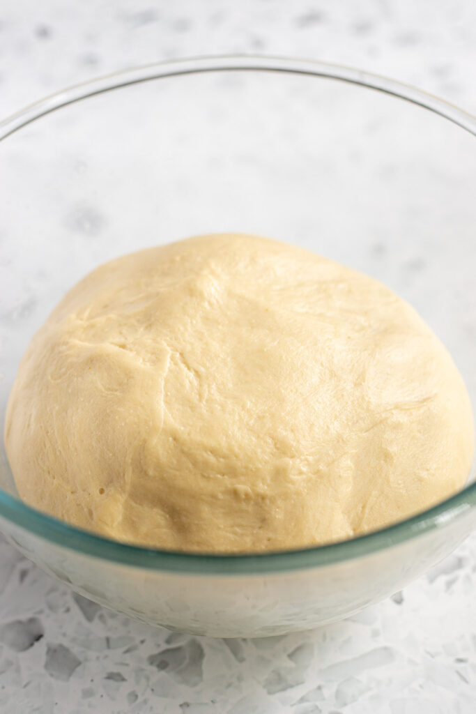 Garlic knot dough puffed up and doubled after its first rise.