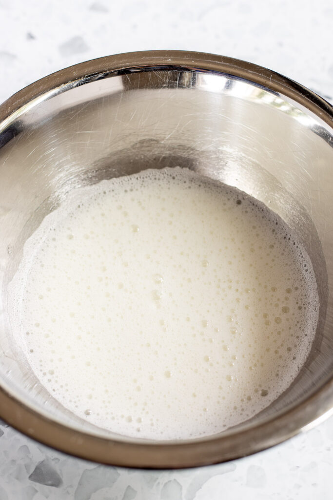 Egg whites beaten to a frothy stage, ready for gradual addition of sugar.
