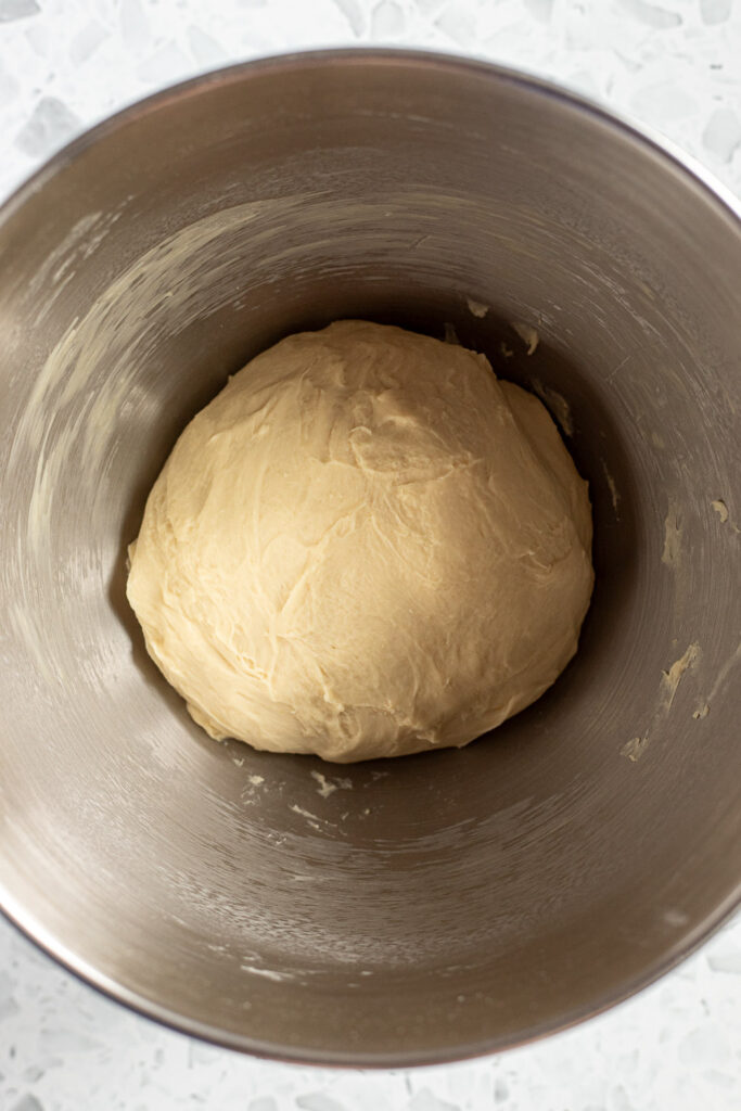 Well-kneaded garlic knot dough in a stand mixer bowl, ready for rising, seen from above.