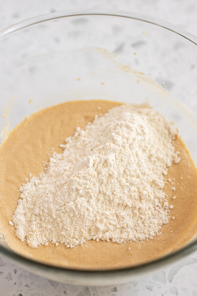 Flour mixture resting on top of cake batter, ready to be mixed in. 