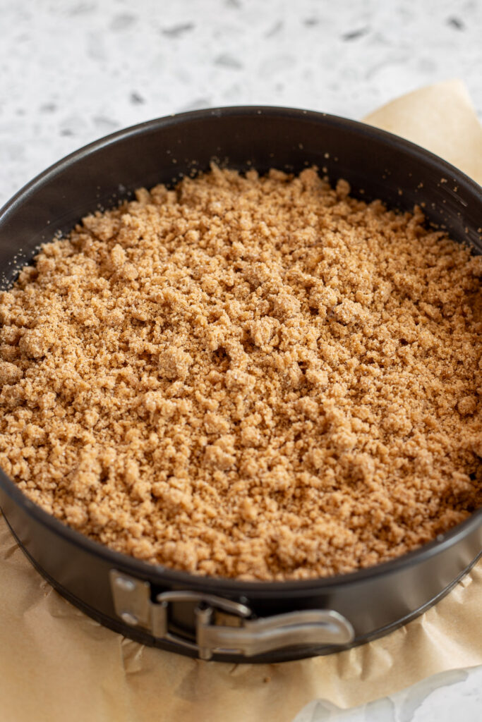 Cinnamon streusel sprinkled atop coffee cake batter, ready to be baked