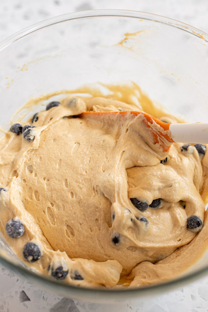 Folding blueberries into the coffee cake batter using a rubber spatula