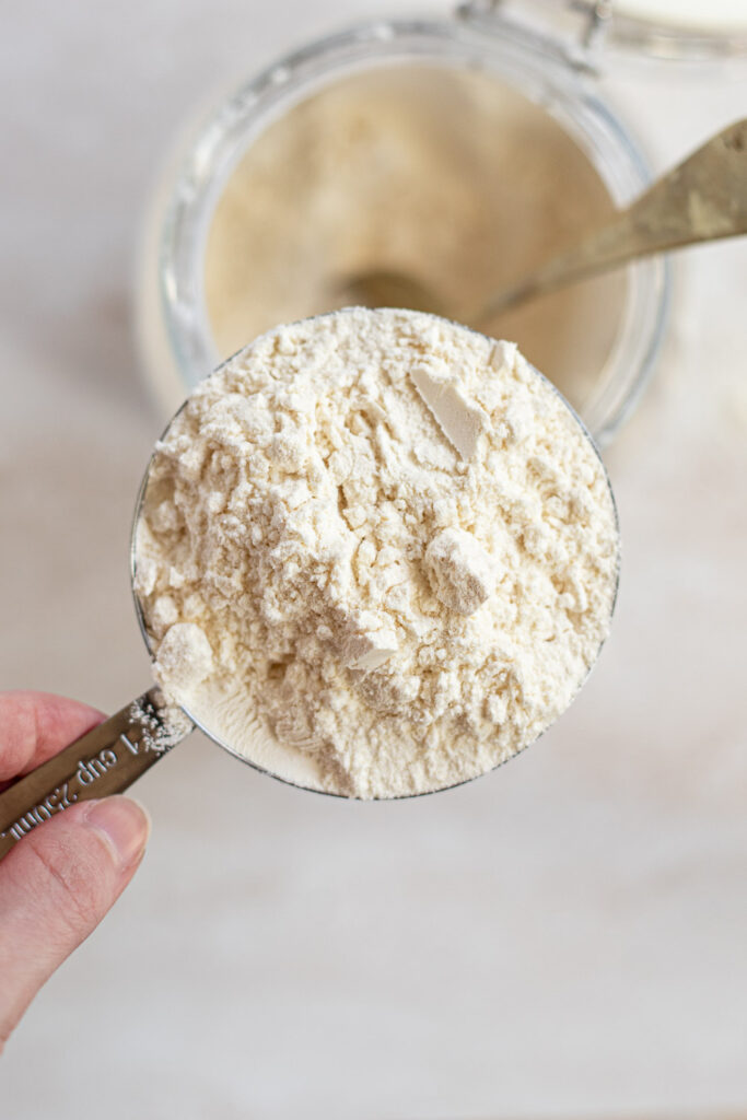 Heaped cup of flour ready to be levelled.