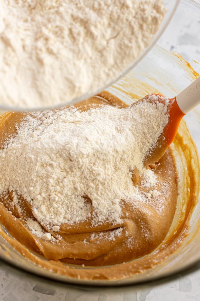 Dry ingredients being added to wet mixture for peanut butter cookies