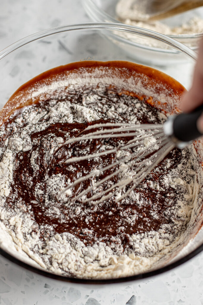 Dry ingredients being whisked into chocolate Guinness cake batter until smooth