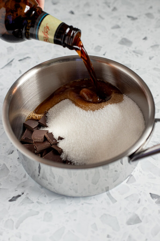 Guinness being poured into a saucepan with sugar and chocolate