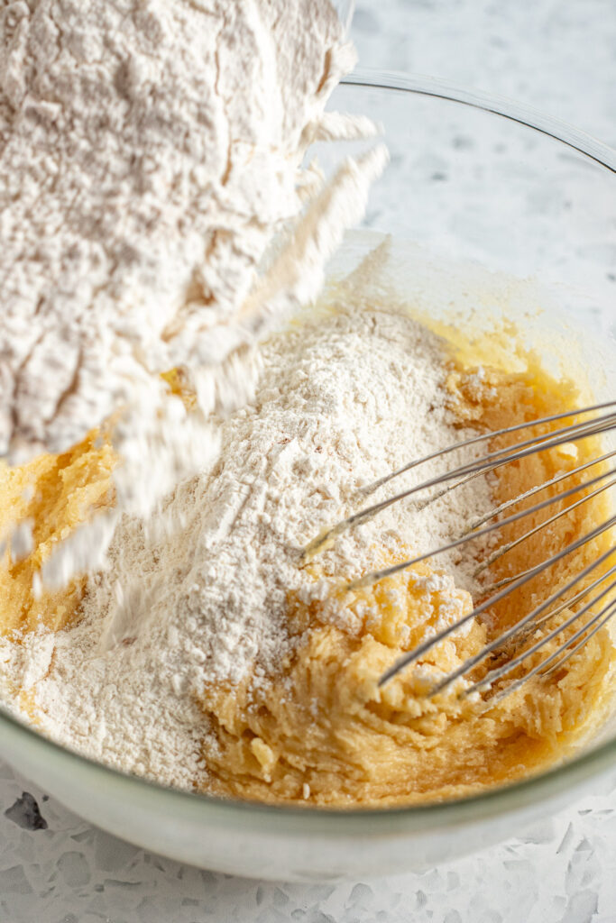Dry ingredients being tipped into wet ingredients to form cookie dough