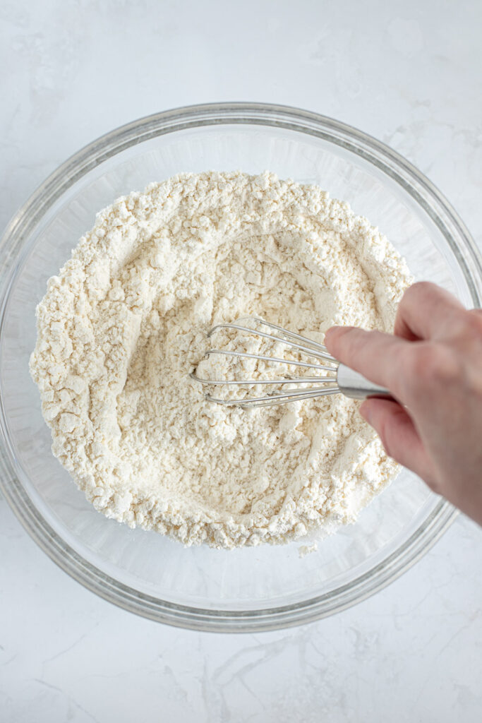 Hand whisking dry ingredients together to make pie crust.