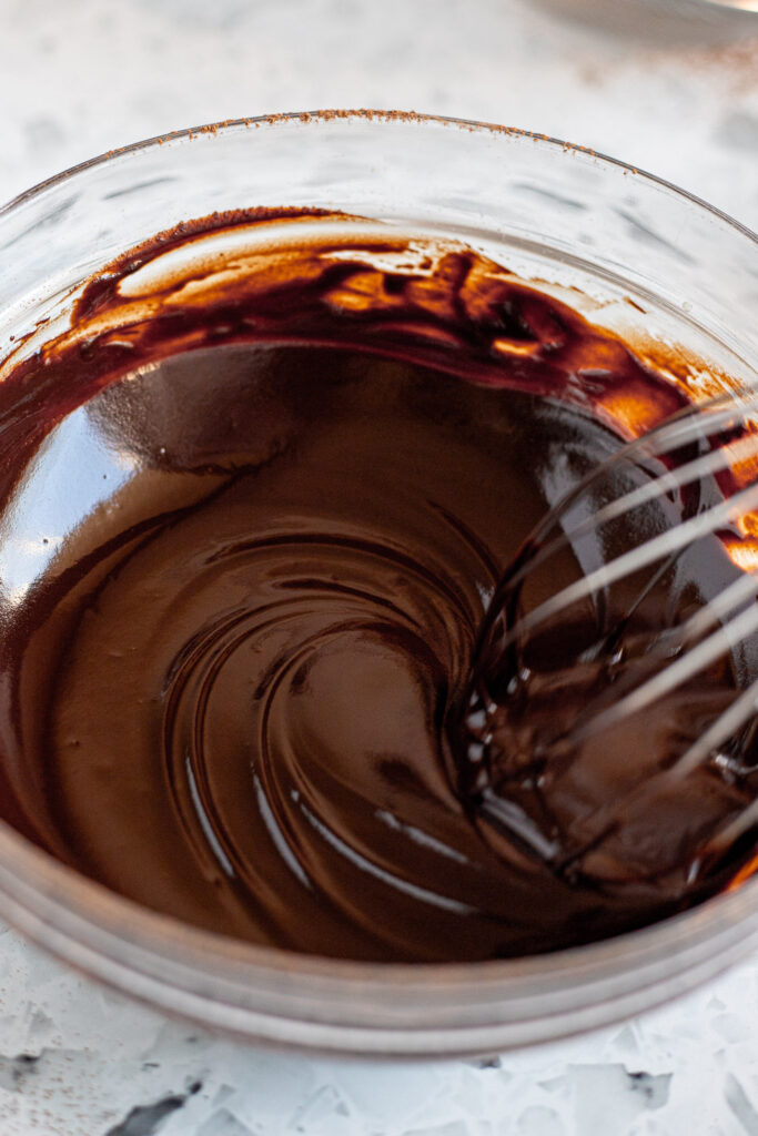 Whisking chocolate mixture until smooth and glossy.