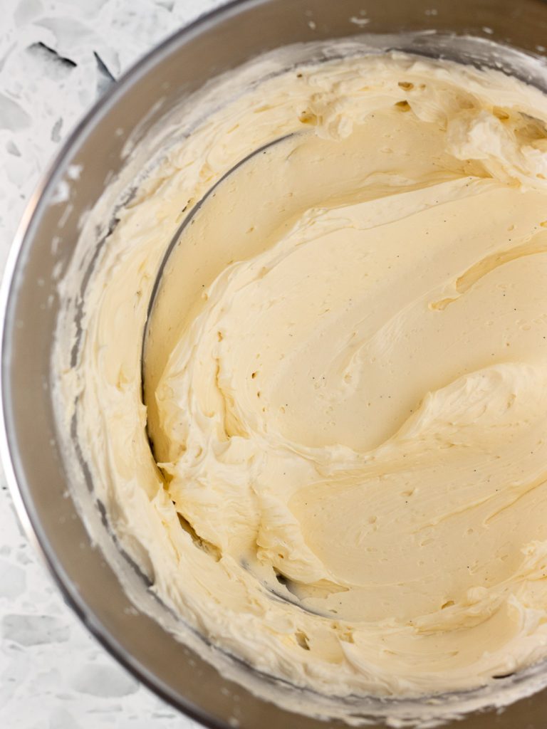Fluffy vanilla Swiss meringue buttercream in a mixer bowl, ready for decorating the cake.